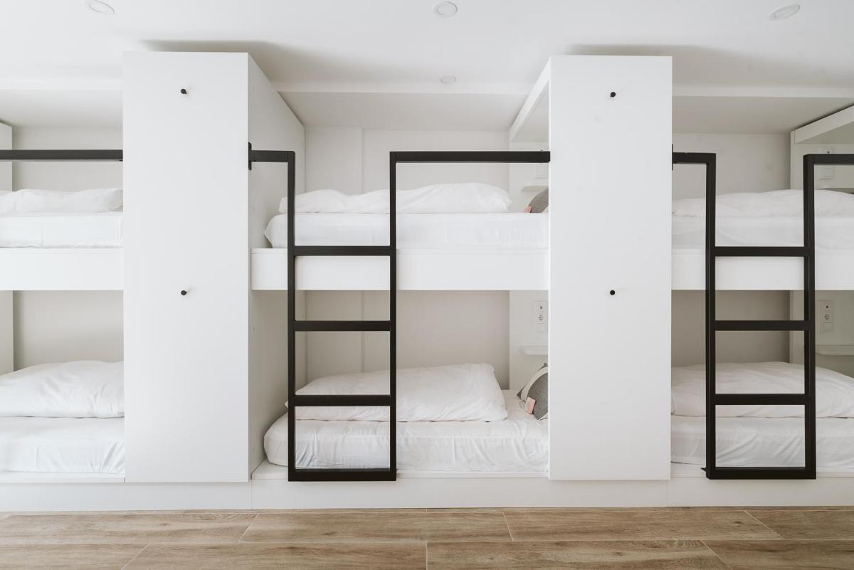 um quarto com 4 beliches e espelhos em The Salty Pelican Yoga & Surf Retreat em Peniche