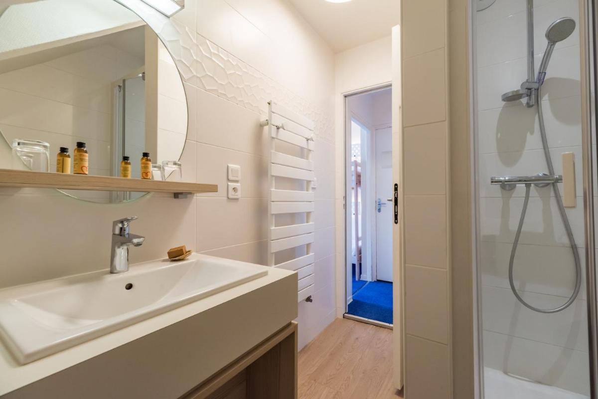 une salle de bain avec un lavabo et une douche dans l'établissement Hôtel Miléade de la Plage - Binic, à Binic