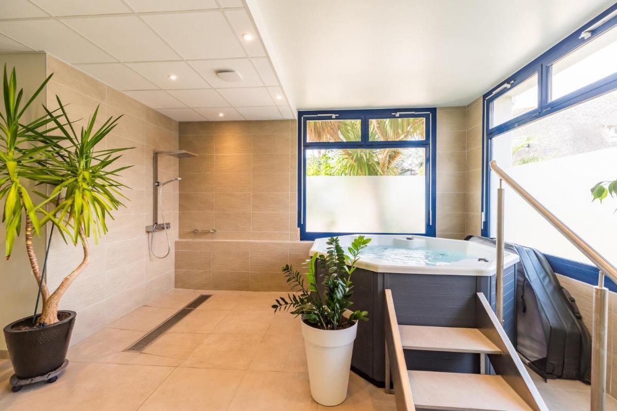 La salle de bains est pourvue d'une baignoire et d'un escalier. dans l'établissement Hôtel Miléade de la Plage - Binic, à Binic