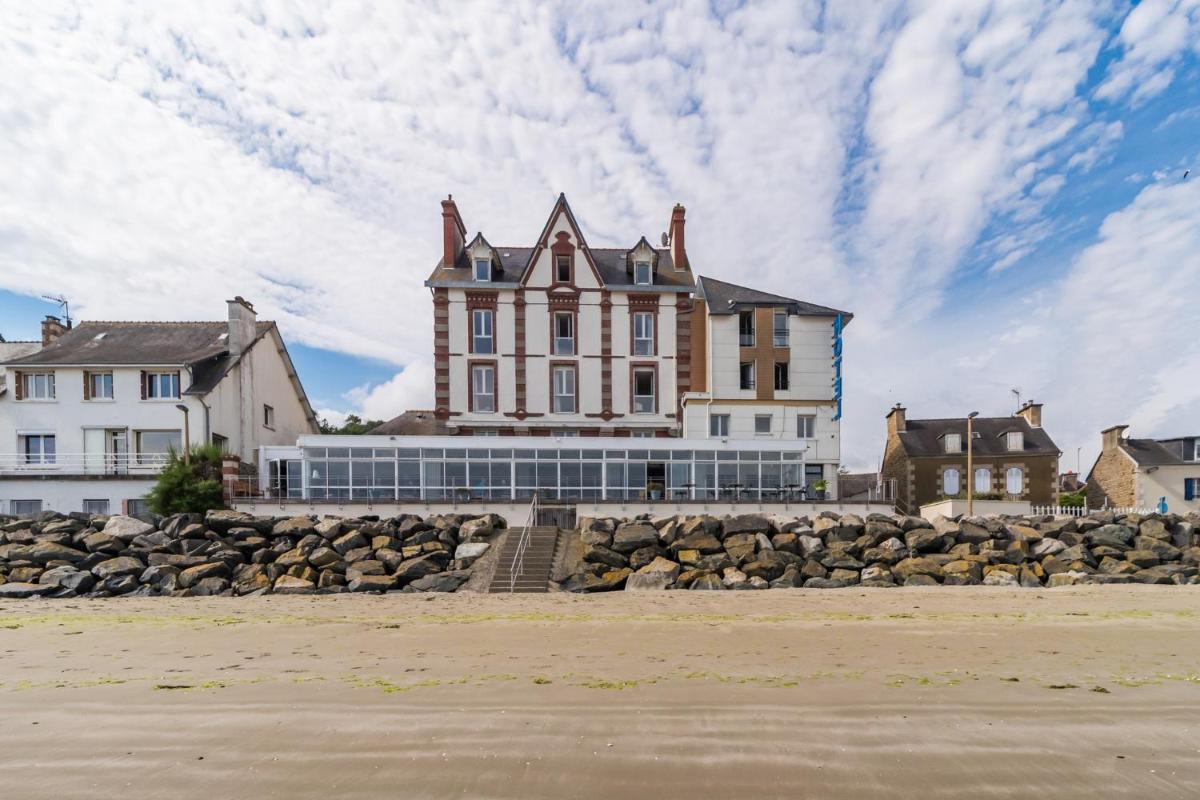 une grande maison sur la rive d'une plage dans l'établissement Hôtel Miléade de la Plage - Binic, à Binic