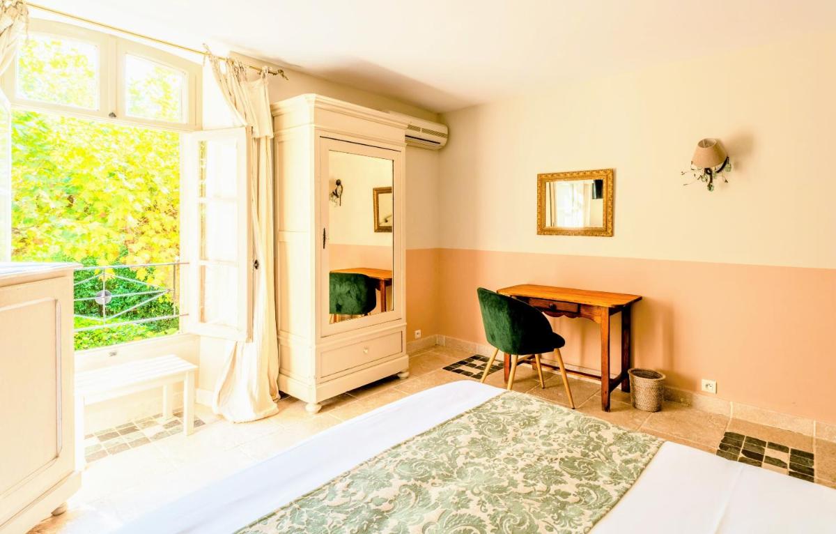 Un ou plusieurs lits dans un hébergement de l'établissement Hôtel Le Mas des Grès & Restaurant Sous les Platanes