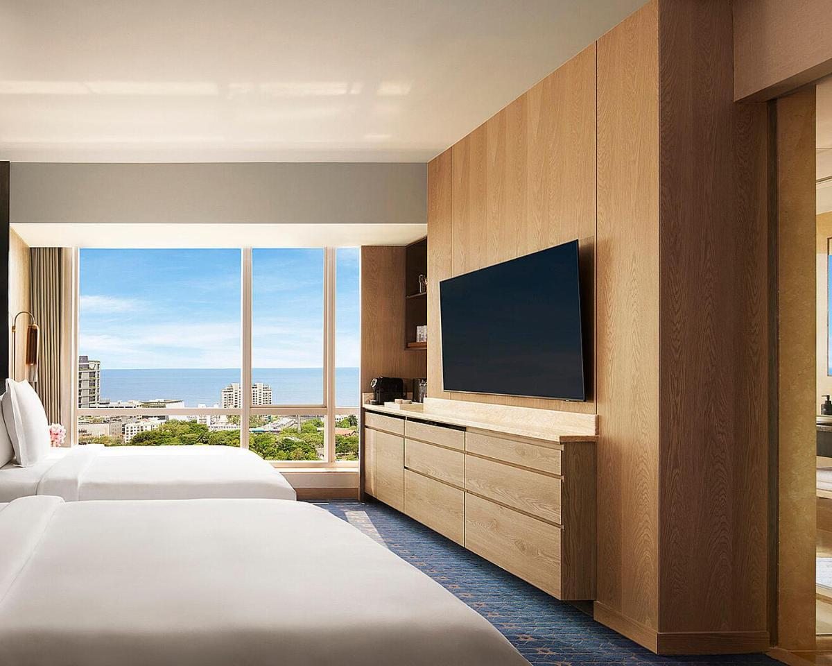 a hotel room with two beds and a flat screen tv at Four Seasons Hotel Mumbai in Mumbai