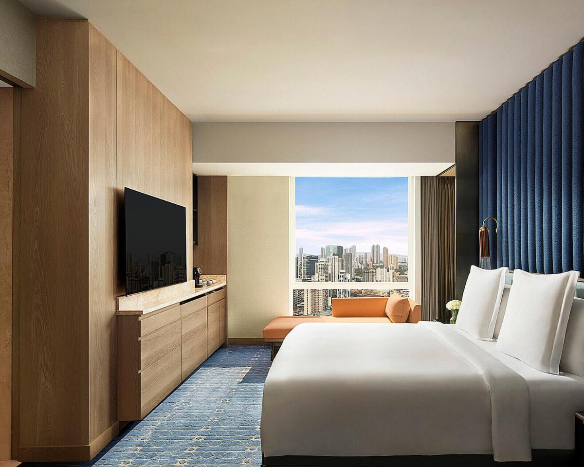 a hotel room with a large bed and a television at Four Seasons Hotel Mumbai in Mumbai