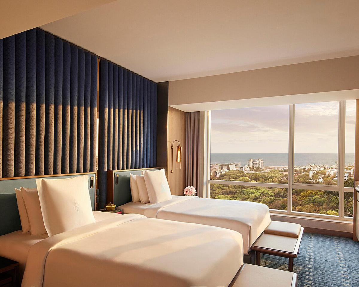 a hotel room with two beds and a large window at Four Seasons Hotel Mumbai in Mumbai