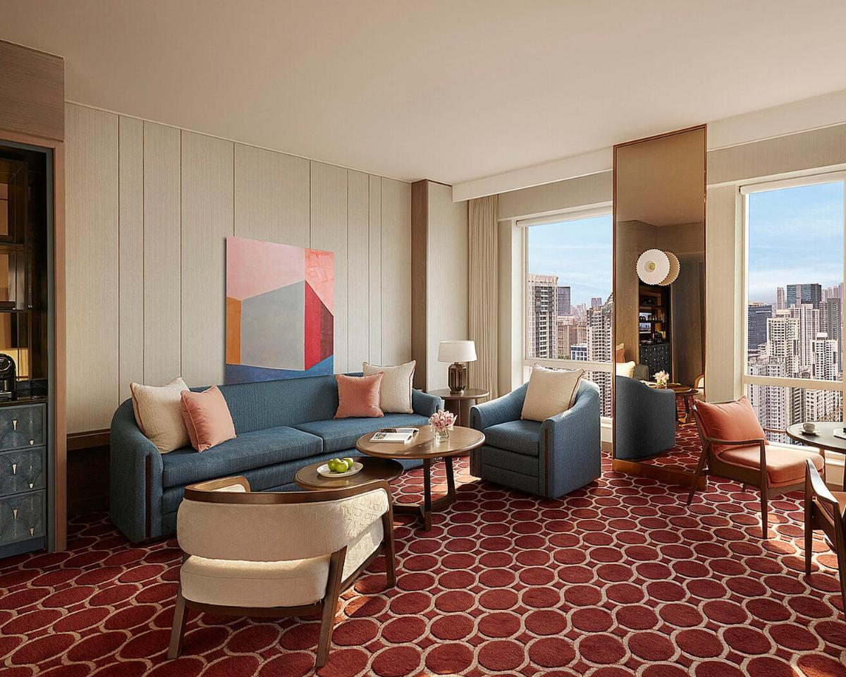 a large living room with a blue couch and chairs at Four Seasons Hotel Mumbai in Mumbai