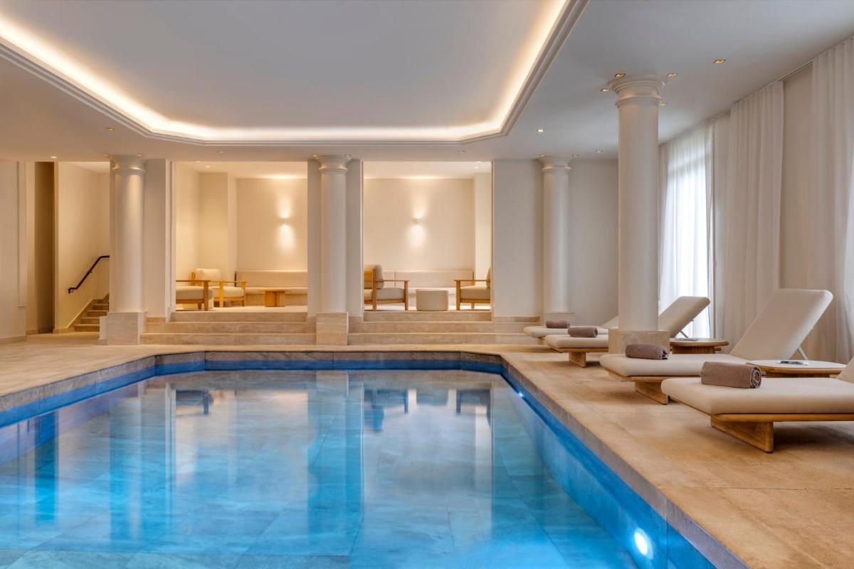 - une piscine dans un hôtel avec des chaises et des tables dans l'établissement InterContinental Hotels Chantilly Chateau Mont Royal by IHG, à Chantilly - une piscine dans un hôtel avec des chaises et des tables dans l'établissement InterContinental Hotels Chantilly Chateau Mont Royal by IHG, à Chantilly