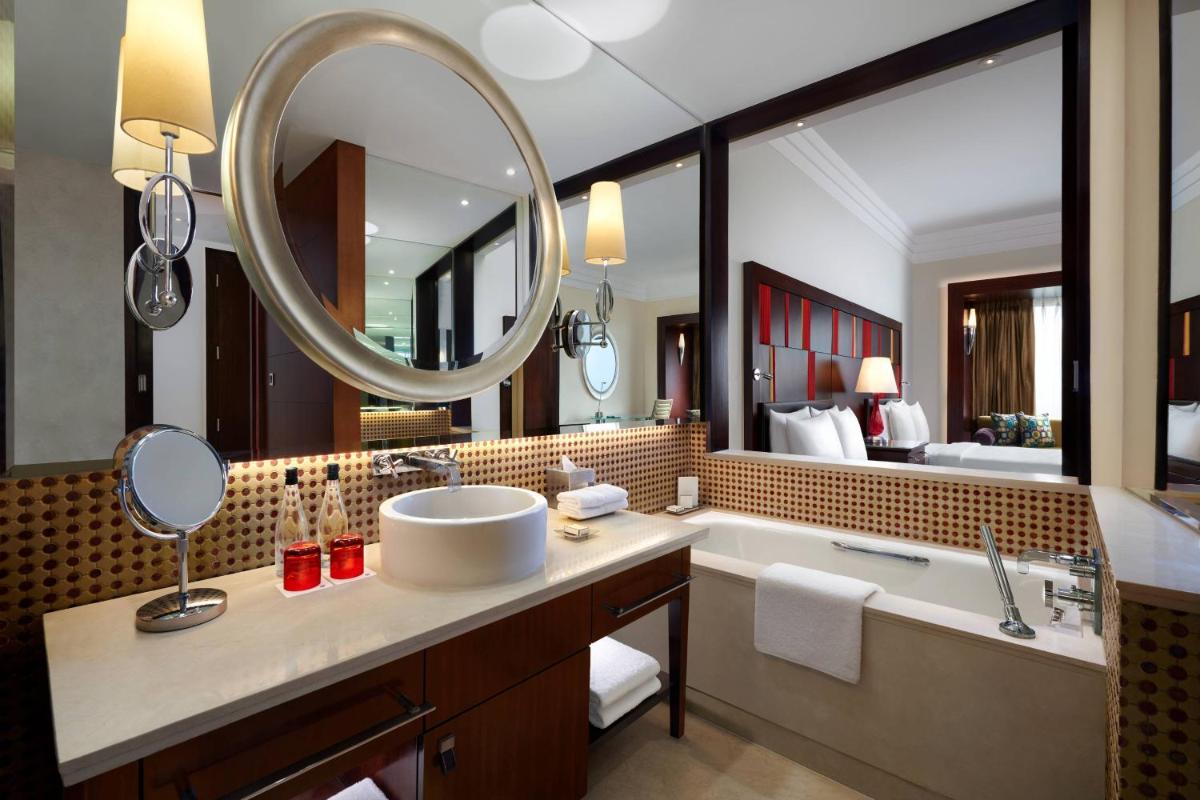 a bathroom with a tub and a sink and a mirror at JW Marriott Hotel Bengaluru in Bengaluru