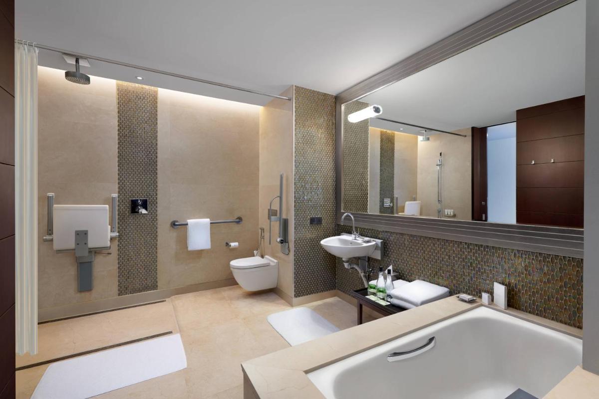 a bathroom with a tub and a toilet and a sink at JW Marriott Hotel Bengaluru in Bengaluru