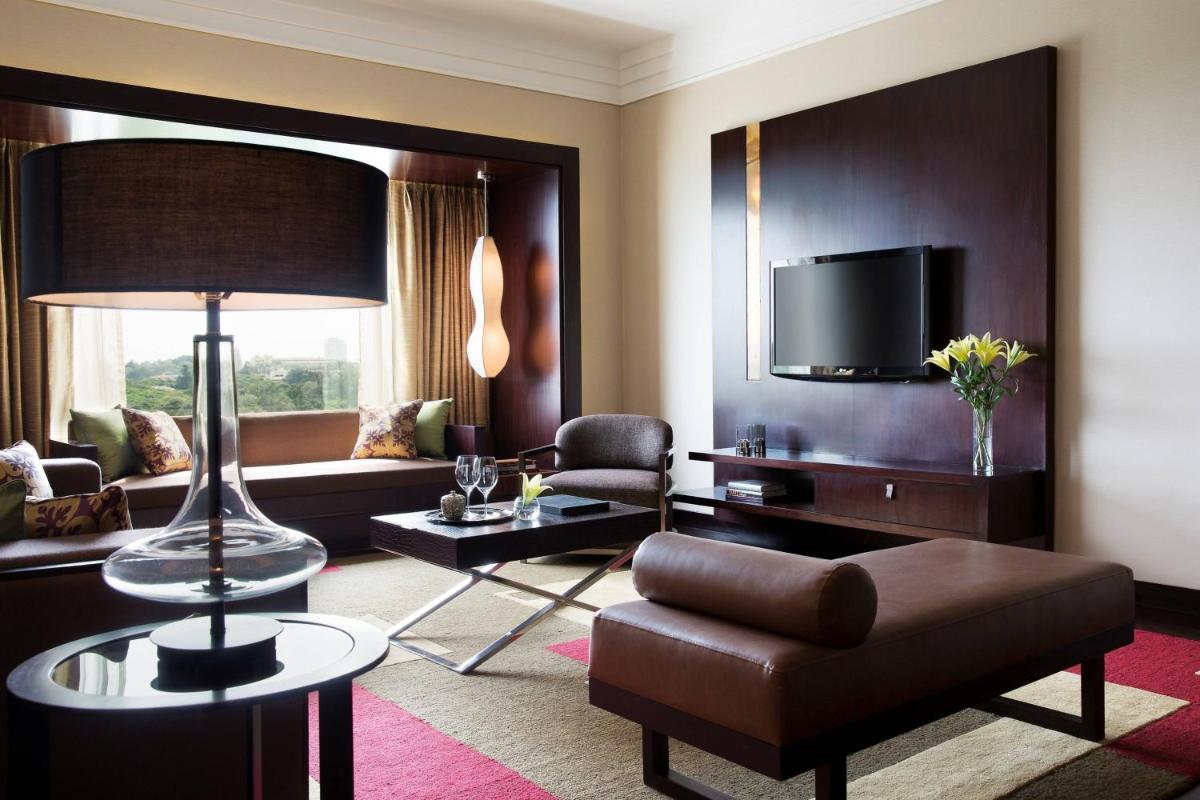 a living room with a couch and a tv at JW Marriott Hotel Bengaluru in Bengaluru