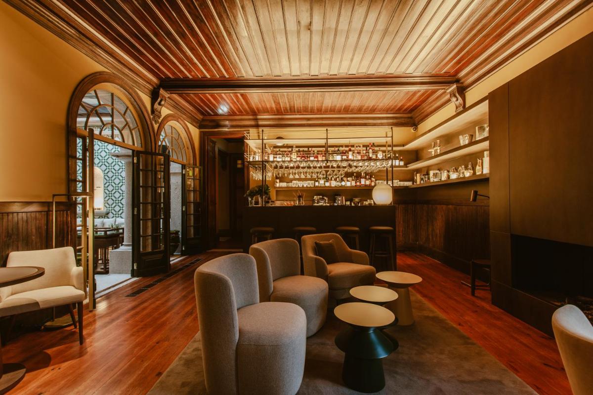 um restaurante com um bar com cadeiras e mesas em Palacete Severo no Porto