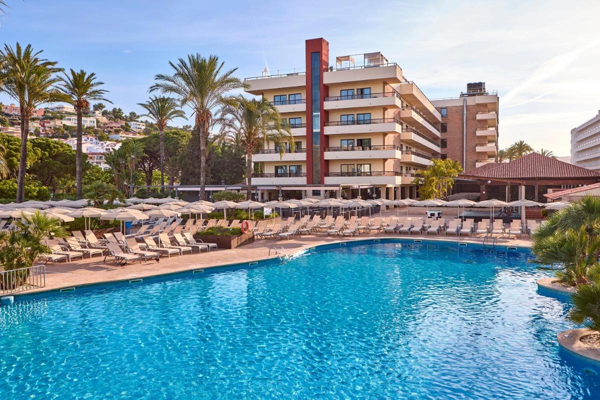 Una piscina con sillas y sombrillas frente a un hotel. en Zafiro Rey Don Jaime, en Santa Ponsa