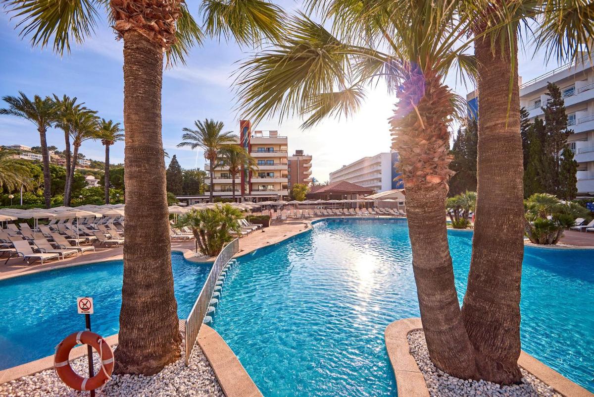 una piscina con palmeras en un resort en Zafiro Rey Don Jaime, en Santa Ponsa