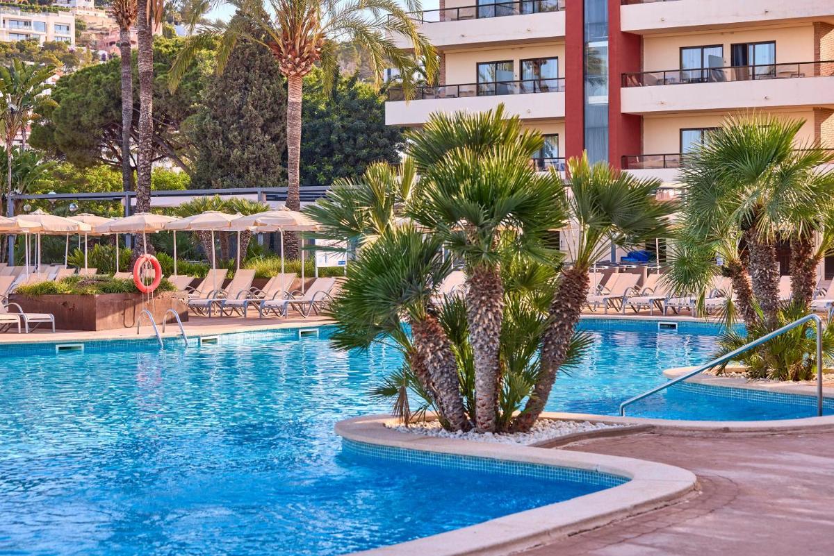 una piscina con palmeras en un hotel en Zafiro Rey Don Jaime, en Santa Ponsa