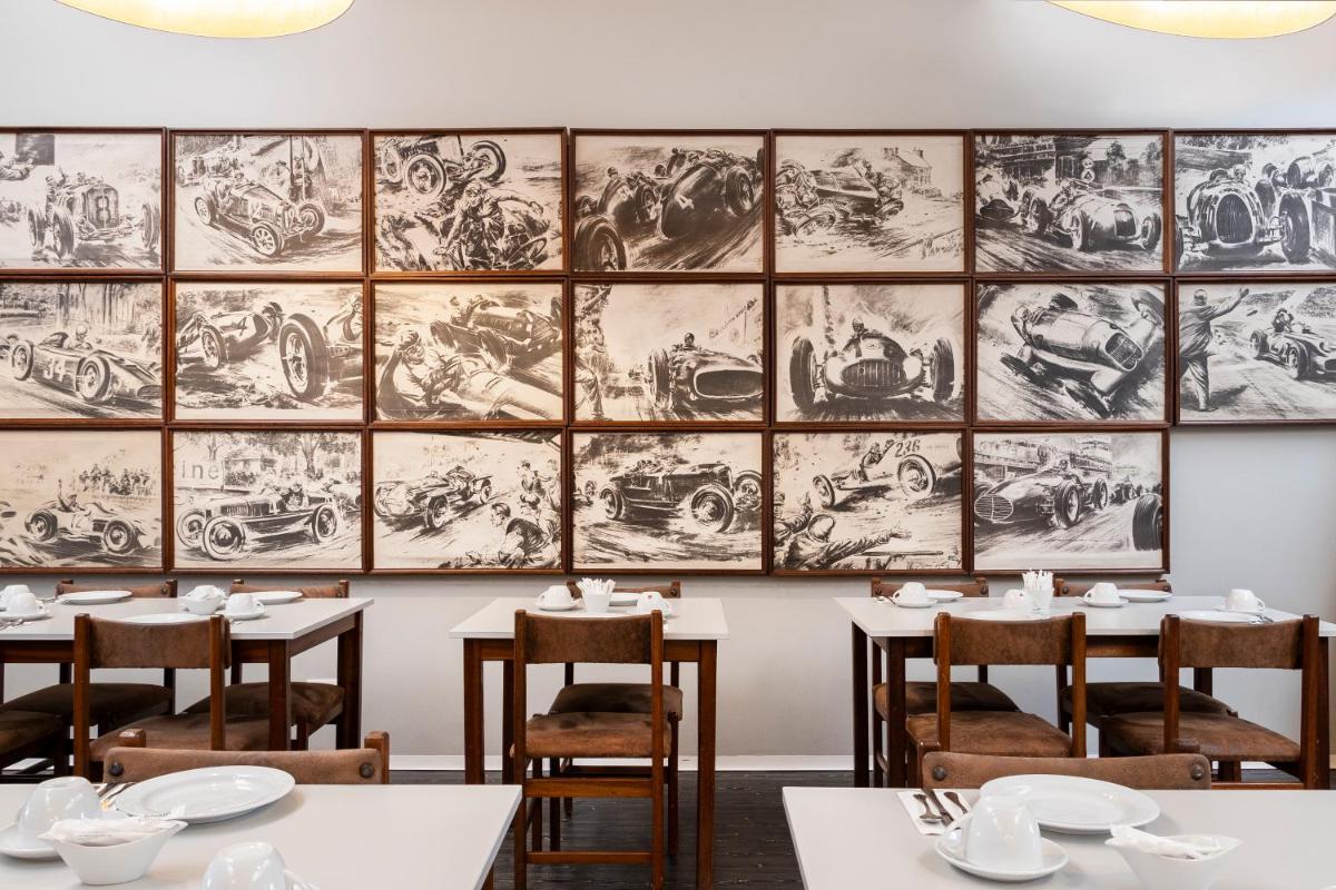 uma sala de jantar com mesas e desenhos na parede em Hotel Rali Viana em Viana do Castelo