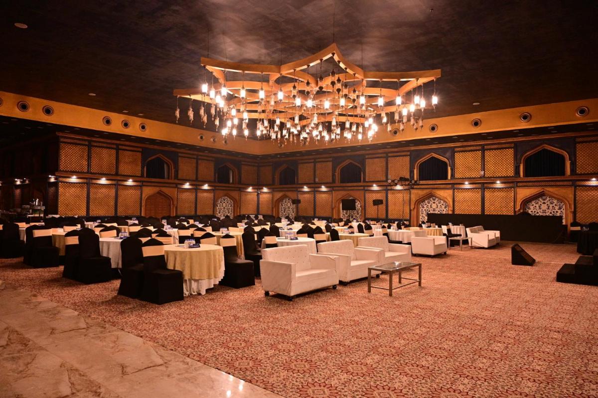 a large banquet hall with white tables and chairs at Holiday Inn Kolkata Airport by IHG in Kolkata