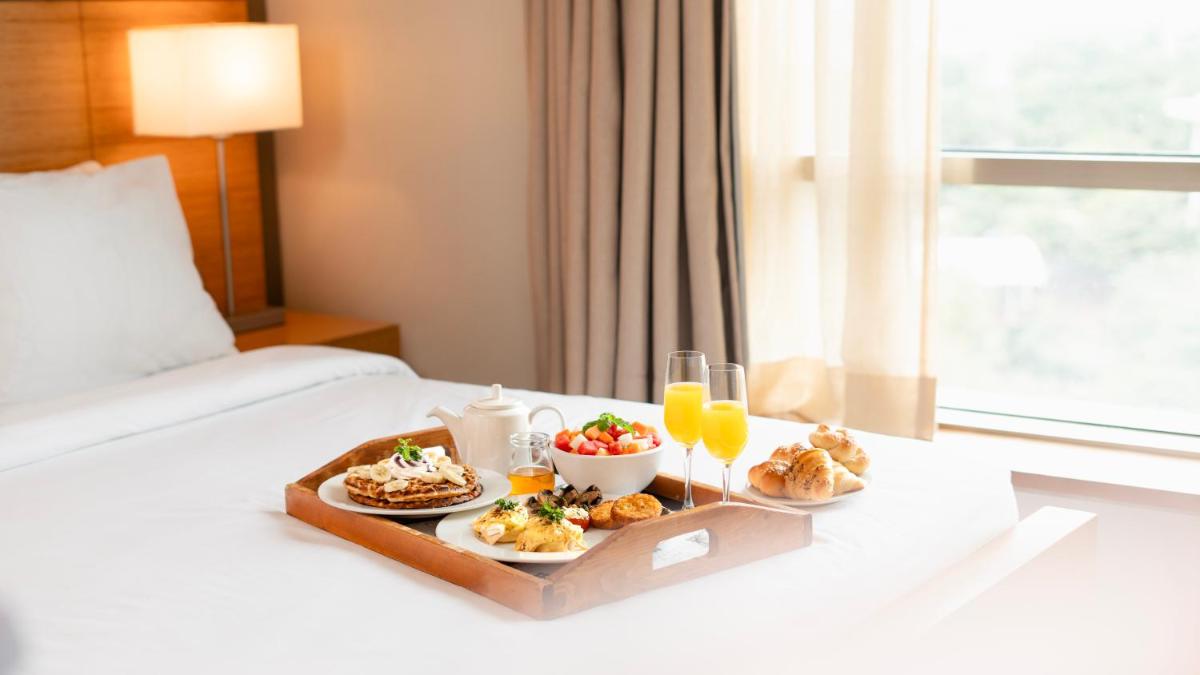 a tray of food and drinks on a bed at Hyatt Place Pune Hinjawadi in Pune