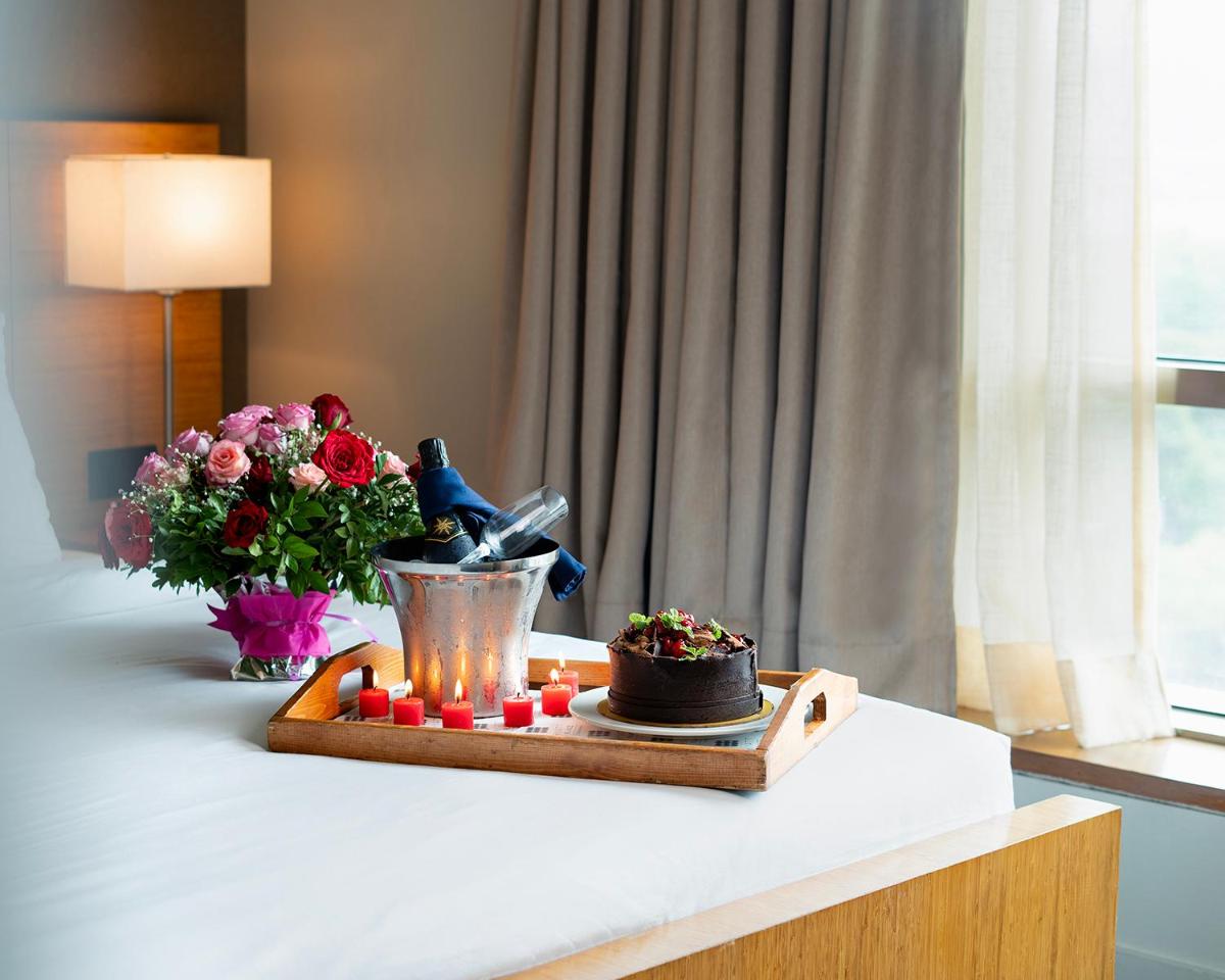 a table with a tray of medicines and a bouquet of flowers at Hyatt Place Pune Hinjawadi in Pune