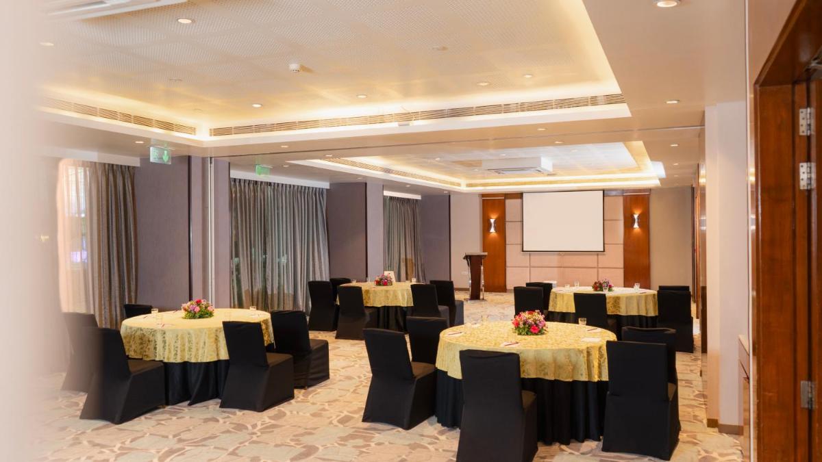 a conference room with tables and chairs and a screen at Hyatt Place Pune Hinjawadi in Pune