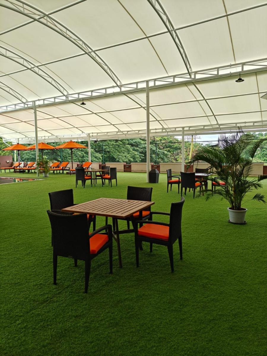 a picnic table and chairs in a patio with an umbrella at Hyatt Place Pune Hinjawadi in Pune