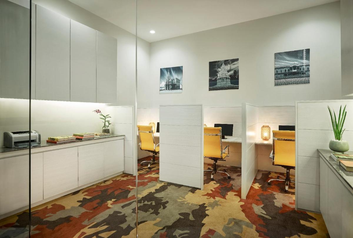an office with white cabinets and yellow chairs and a desk at Vivanta Pune, Hinjawadi in Pune