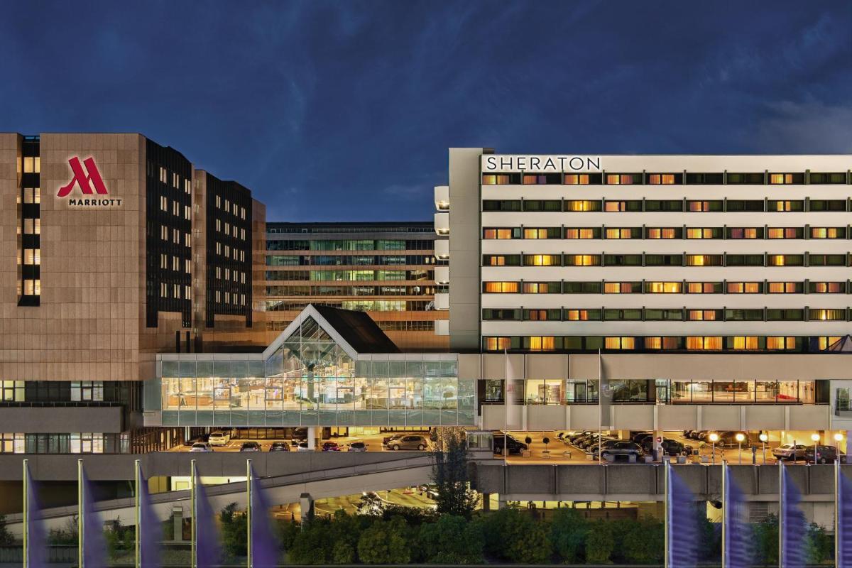 ein großes Gebäude mit einem Schild an der Seite in der Unterkunft Frankfurt Airport Marriott Hotel in Frankfurt am Main ein großes Gebäude mit einem Schild an der Seite in der Unterkunft Frankfurt Airport Marriott Hotel in Frankfurt am Main