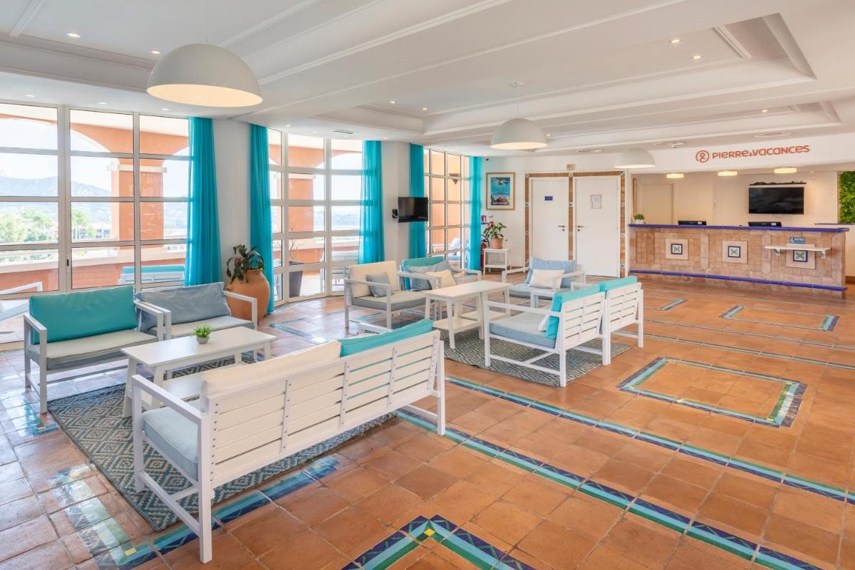 un hall avec des chaises et des tables dans un bâtiment dans l'établissement Hôtel de l'Esterel Pierre & Vacances, à Agay