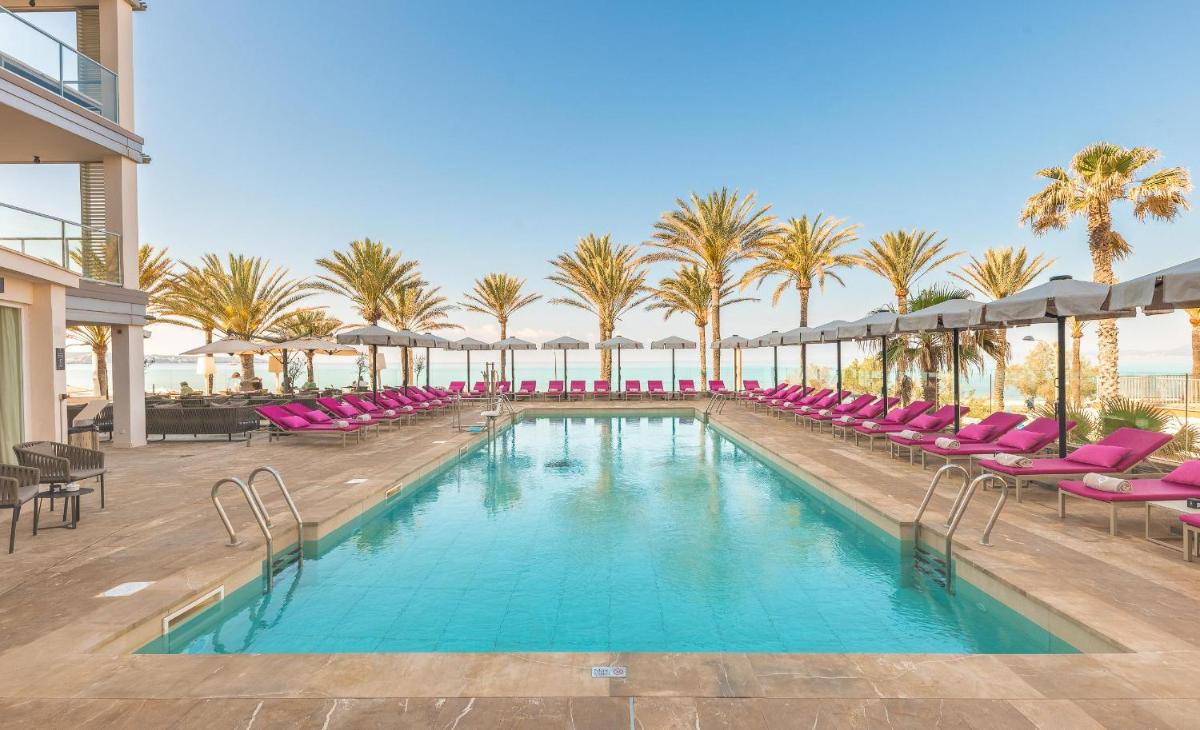 una piscina con sillas rosas y palmeras en Pure Salt Garonda - Adults Only, en Playa de Palma