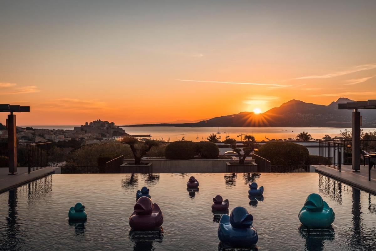 - une piscine avec des cygnes dans l'eau au coucher du soleil dans l'établissement La Villa Calvi, à Calvi - une piscine avec des cygnes dans l'eau au coucher du soleil dans l'établissement La Villa Calvi, à Calvi