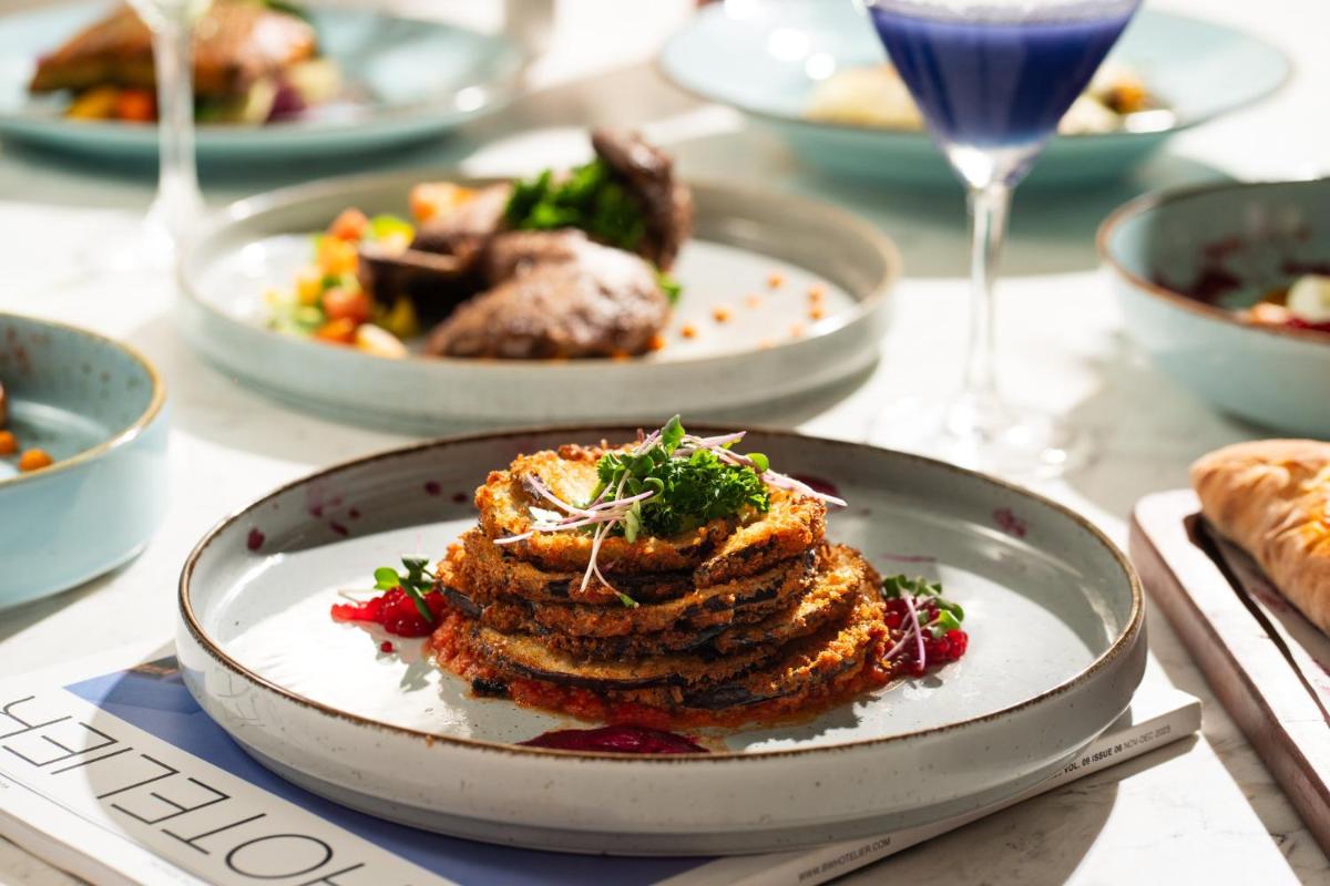 a plate of food on a table with plates of food at Crowne Plaza Ahmedabad City Centre by IHG in Ahmedabad