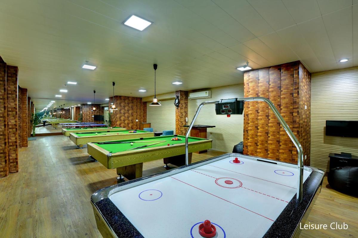 a row of pool tables in a room with billards at Hotel Clarks Shiraz in Agra