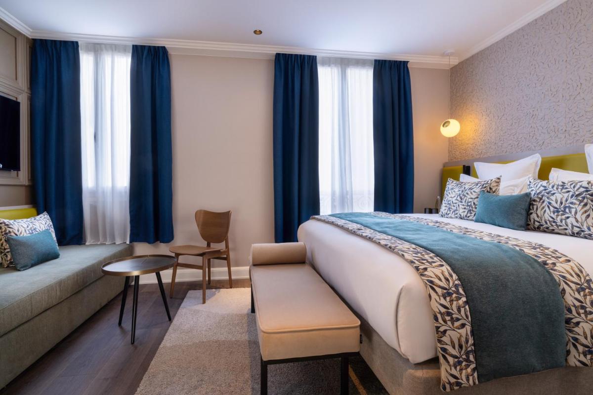 une chambre d'hôtel avec un lit et un canapé dans l'établissement Hôtel L'Ormaie & Spa, à Paris