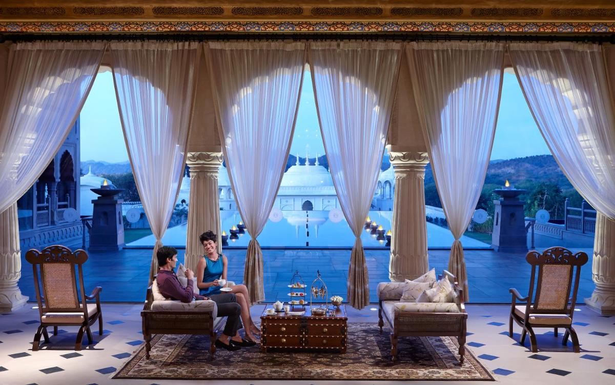 two people sitting in chairs in a room with a view at Fairmont Jaipur in Jaipur
