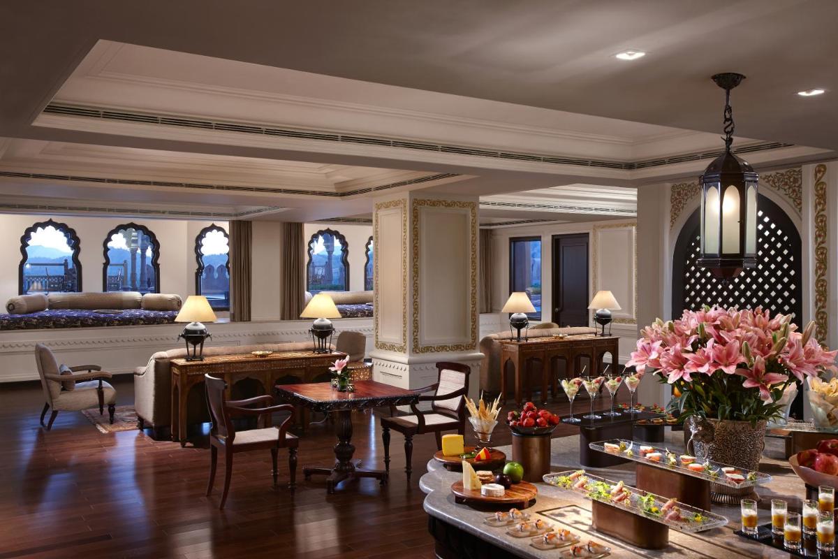 a lobby of a hotel with tables and chairs at Fairmont Jaipur in Jaipur