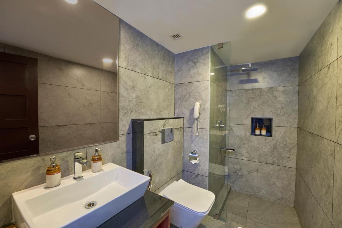 a bathroom with a sink and a shower and a toilet at Casino Hotel - CGH Earth, Cochin in Cochin a bathroom with a sink and a shower and a toilet at Casino Hotel - CGH Earth, Cochin in Cochin