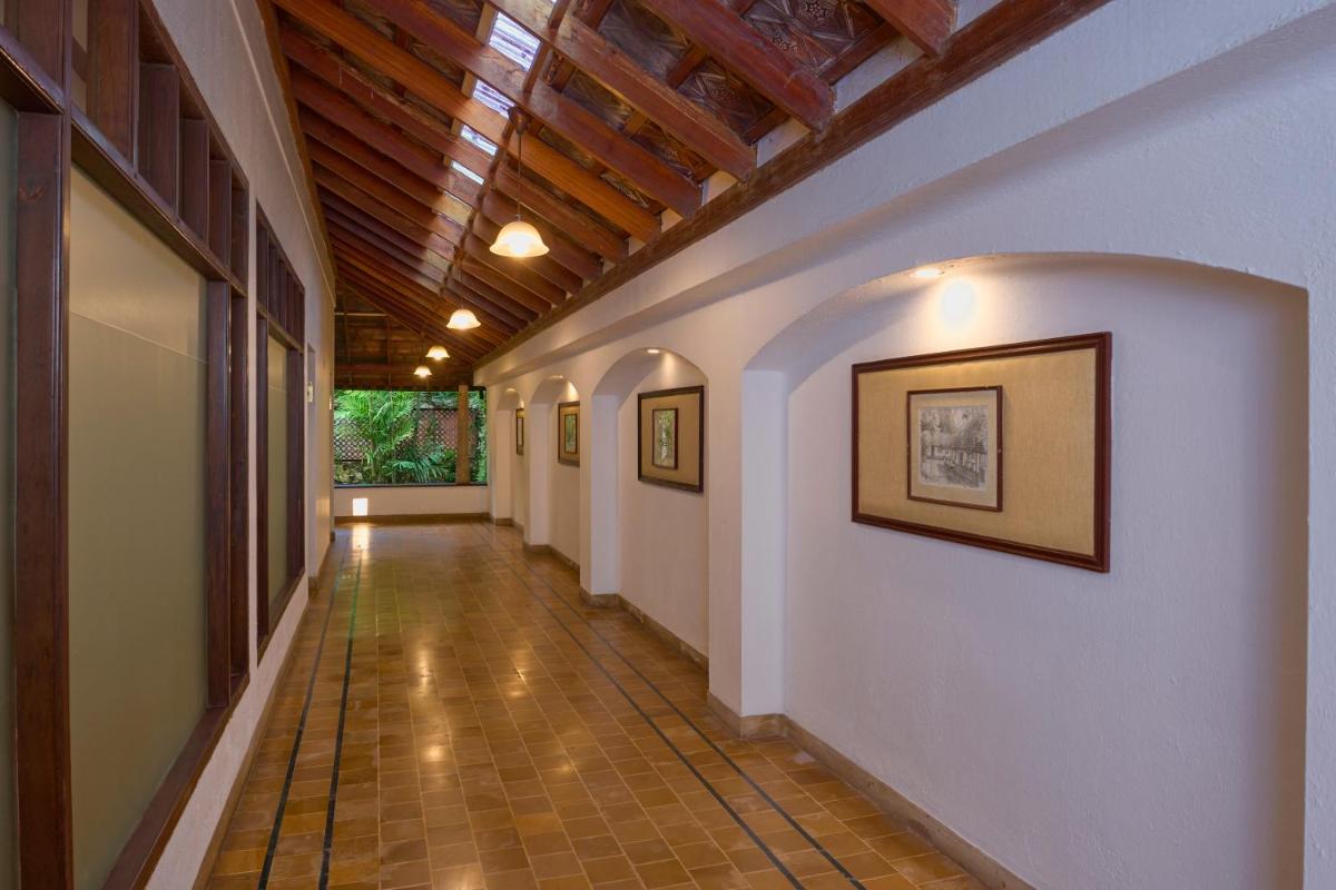 a hallway with white walls and a wooden ceiling at Casino Hotel - CGH Earth, Cochin in Cochin