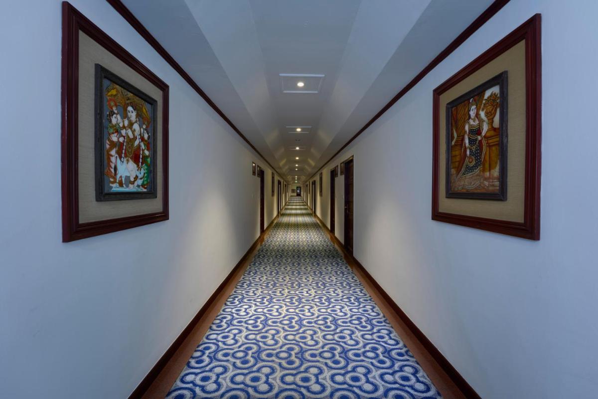 a long hallway with paintings on the walls at Casino Hotel - CGH Earth, Cochin in Cochin