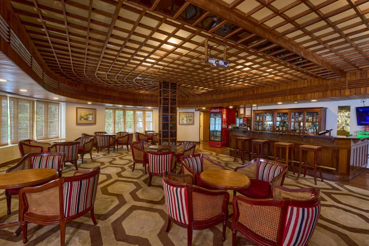 a restaurant with tables and chairs and a bar at Casino Hotel - CGH Earth, Cochin in Cochin