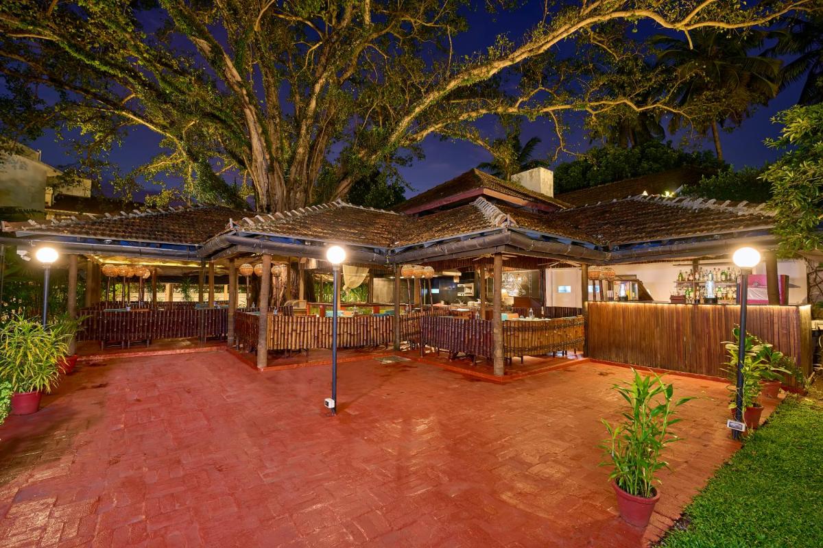 a house with a fence and a tree at night at Casino Hotel - CGH Earth, Cochin in Cochin