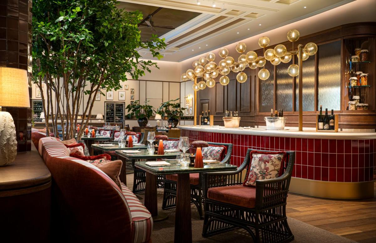 ein Restaurant mit Tischen und Stühlen und einer Bar in der Unterkunft Brunfels Hotel, in the Unbound Collection by Hyatt in Mainz