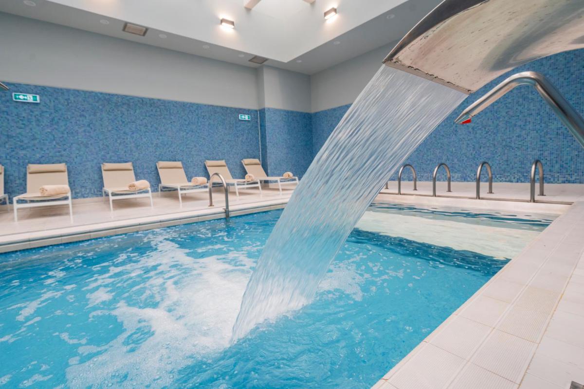 uma piscina com cascata num quarto de hospital em Gaia Residence em Vila Nova de Gaia