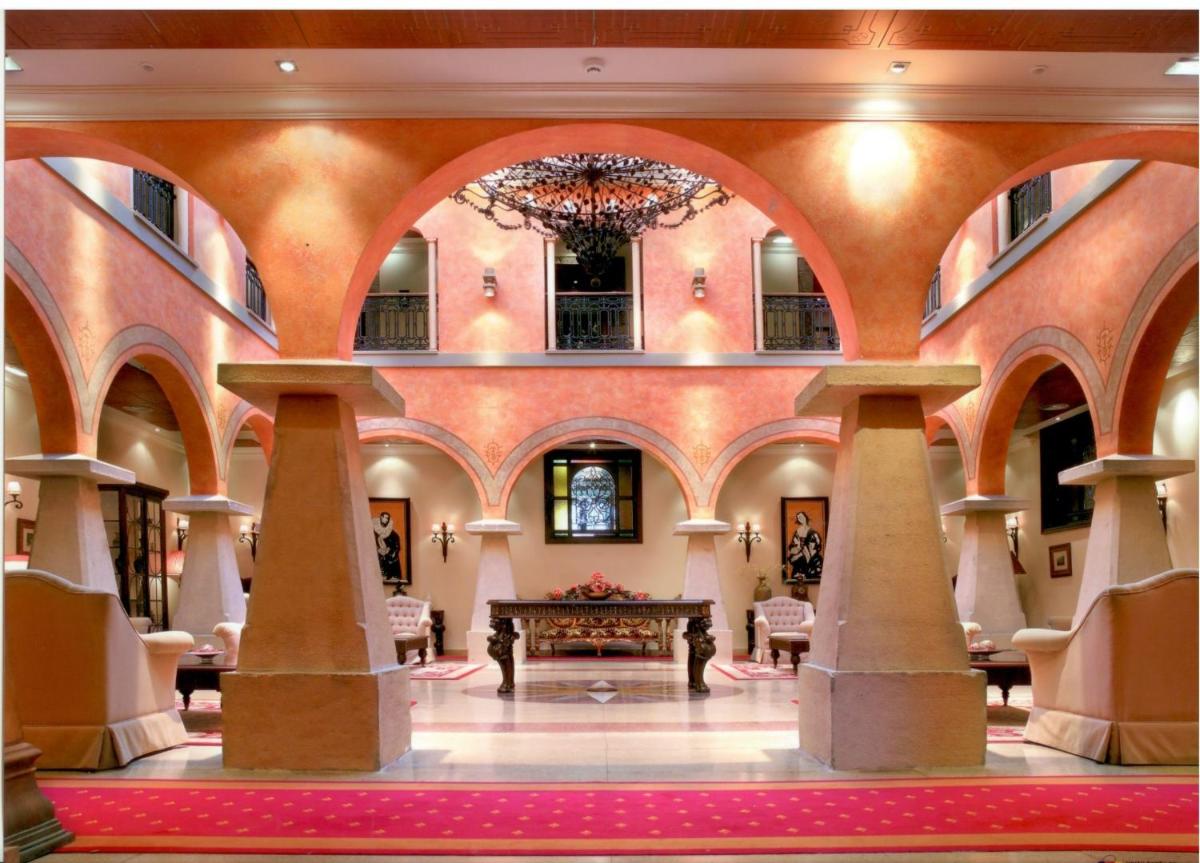 un gran salón con una lámpara de araña en un edificio en Hotel Palacio de la Magdalena, en Soto del Barco