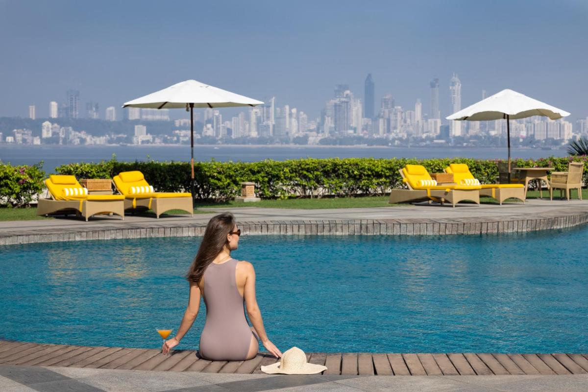a woman is sitting next to a swimming pool at Trident Nariman Point in Mumbai a woman is sitting next to a swimming pool at Trident Nariman Point in Mumbai