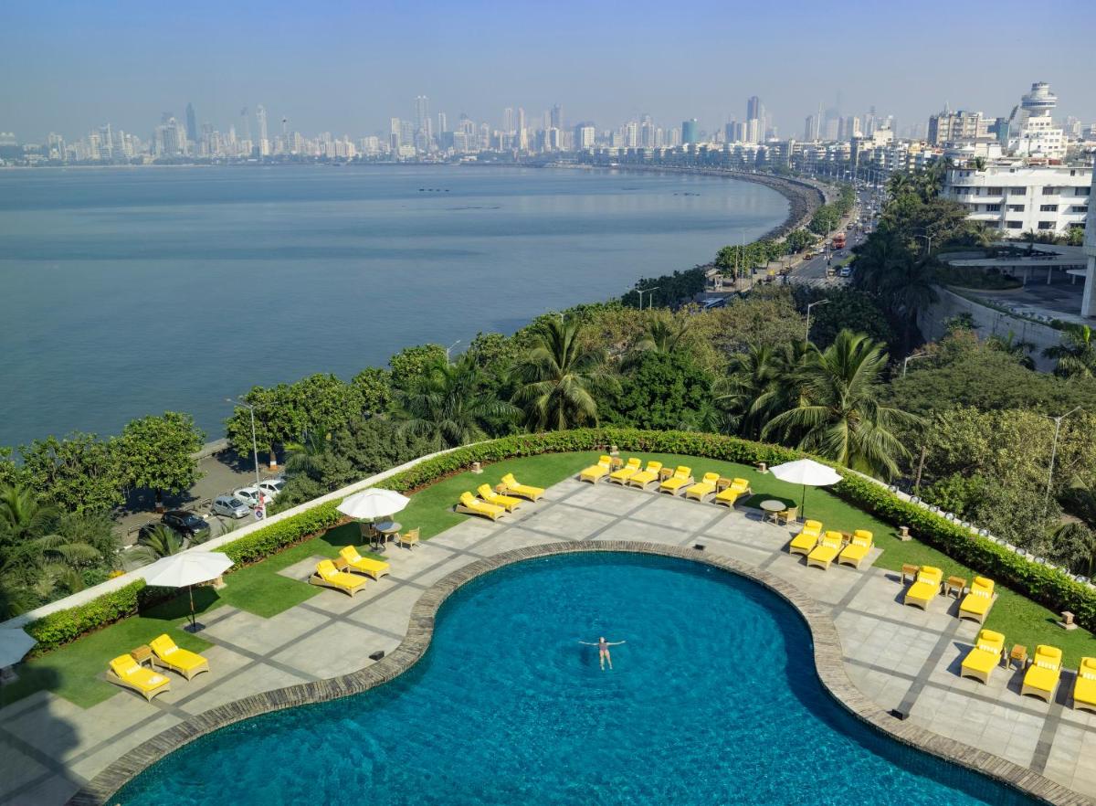 an overhead view of a swimming pool with chairs and umbrellas at Trident Nariman Point in Mumbai an overhead view of a swimming pool with chairs and umbrellas at Trident Nariman Point in Mumbai