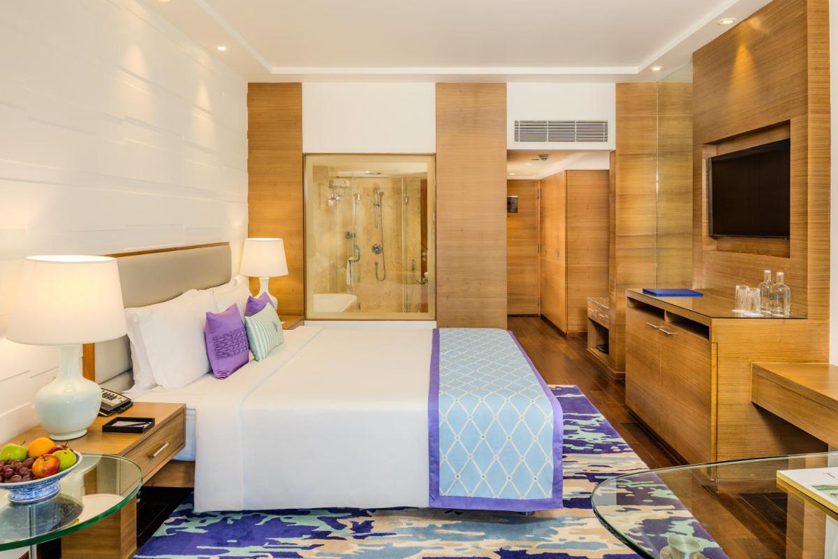 a hotel room with a bed and a television at Vivanta Goa, Panaji in Panaji a hotel room with a bed and a television at Vivanta Goa, Panaji in Panaji