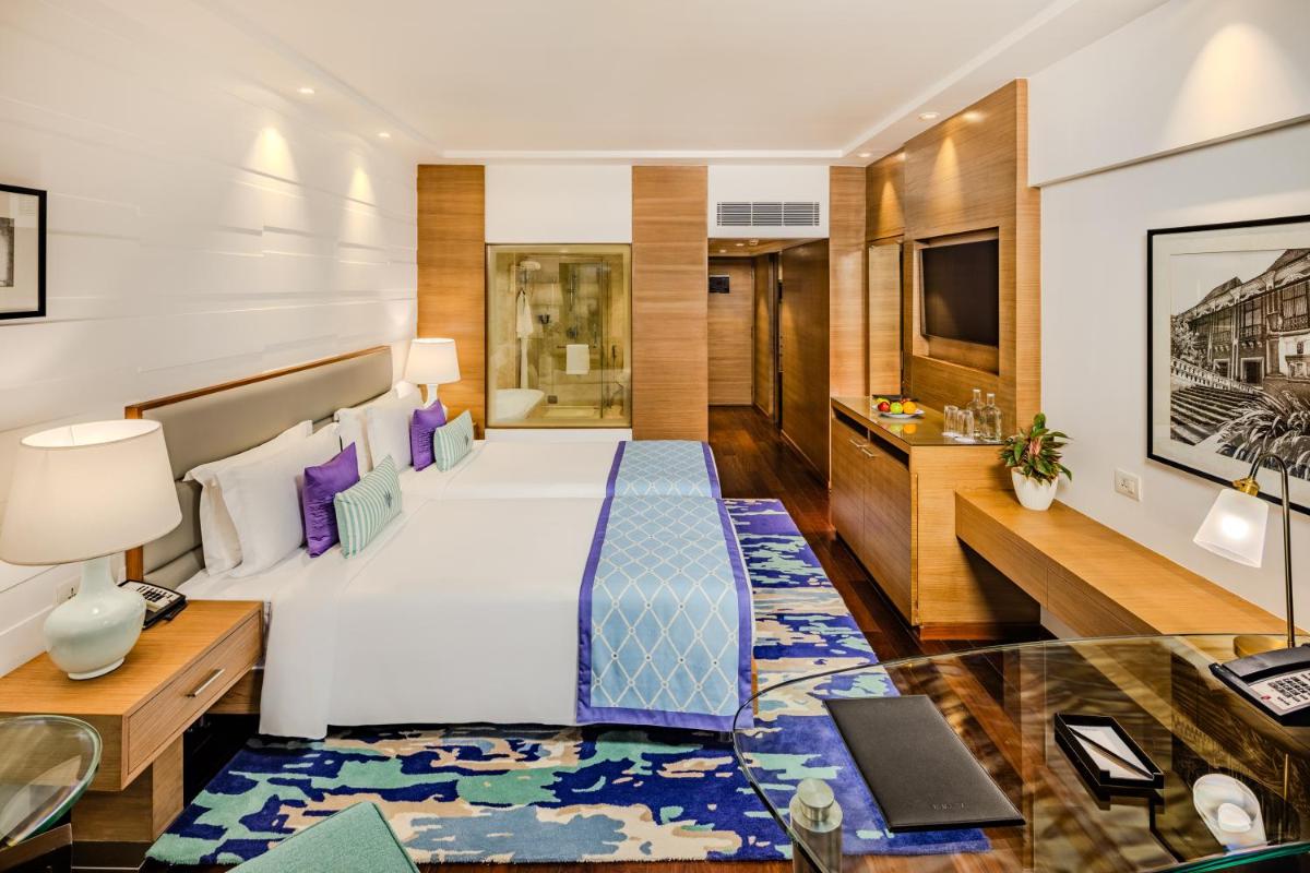 a hotel room with a bed and a desk at Vivanta Goa, Panaji in Panaji a hotel room with a bed and a desk at Vivanta Goa, Panaji in Panaji