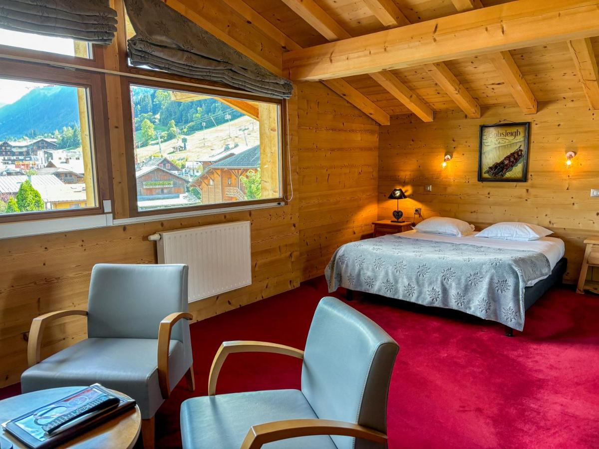 une chambre avec un lit, des chaises et une fenêtre dans l'établissement Hôtel Igloo, à Morzine