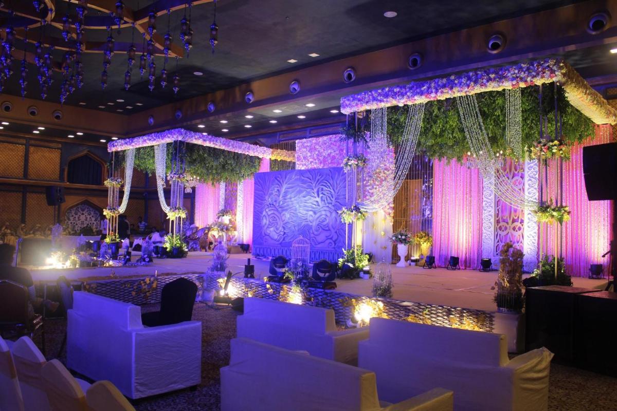 a banquet hall with white chairs and purple lighting at Holiday Inn Kolkata Airport by IHG in Kolkata