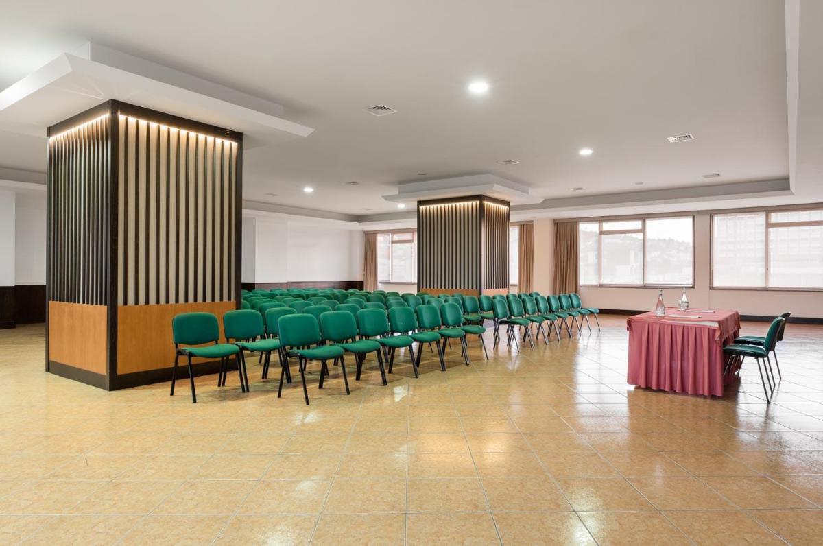 uma sala de conferências com cadeiras verdes e uma mesa vermelha em Exe São Lázaro em Brangança mais 41 fotografias
