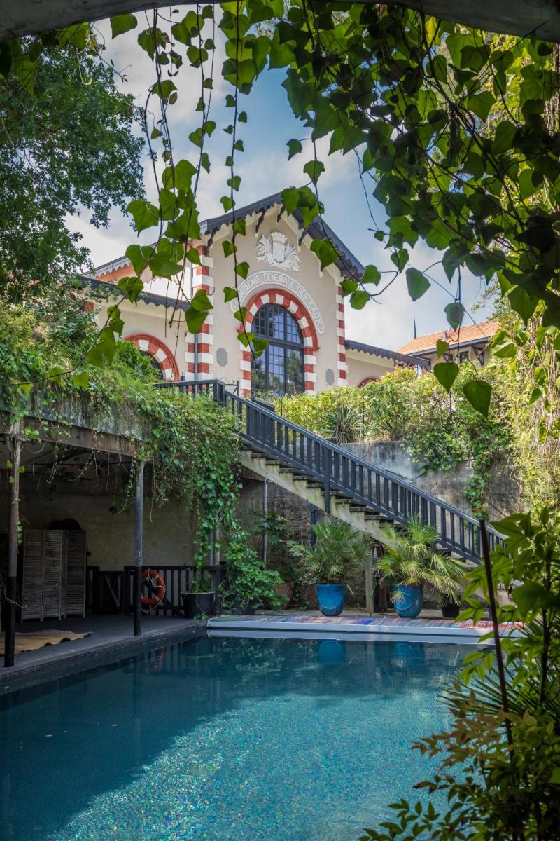 une maison avec une piscine devant un bâtiment dans l'établissement Hôtel Ville d'Hiver, à Arcachon