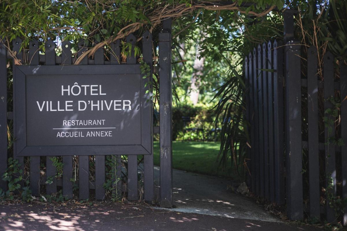 un panneau pour un hôtel ville dixon à côté d'une clôture dans l'établissement Hôtel Ville d'Hiver, à Arcachon